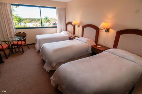 特拉玛斯阿拉佩阿拉培温泉全包Spa度假村的酒店客房设有四张床、一张桌子和一扇窗户。