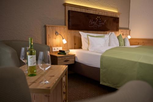 上施陶芬蒂罗尔酒店的酒店客房带一张床和两杯葡萄酒