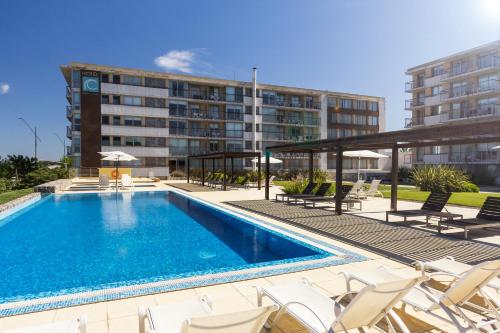 科洛尼亚-德尔萨克拉门托科洛尼亚地道酒店的一座带椅子的游泳池以及一座建筑