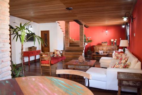 康赛瓦托利亚Pousada Bela Cigana的客厅设有白色沙发和红色墙壁。