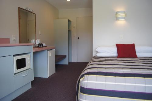哈斯特遗产公园汽车旅馆的酒店客房带一张床和一个厨房