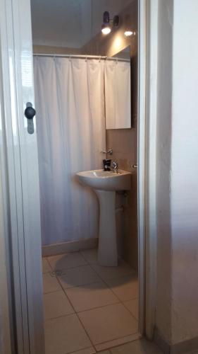 皮里亚波利斯Apartamentos del Este的白色的浴室设有水槽和淋浴。