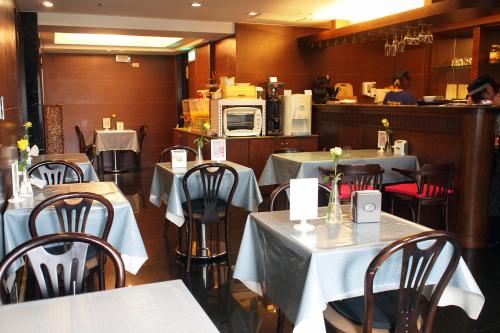台北宝格利时尚旅馆的一间带白色桌椅的餐厅和一间厨房