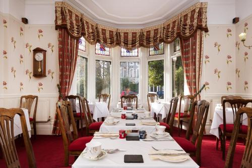 卡迪夫林肯之家私人酒店的用餐室设有桌椅和窗户。