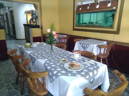 麦德林Hotel Las Rampas的一间用餐室,配有两把桌子和椅子,并提供一盘食物
