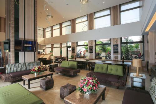 新竹达龙商旅 的大堂配有沙发、桌子和窗户。
