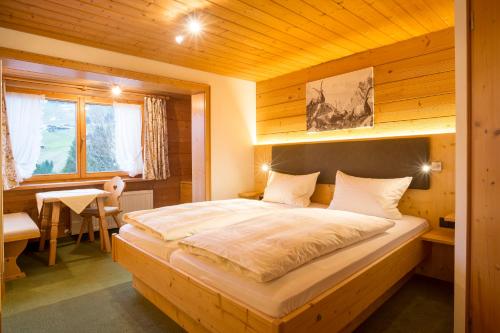米特尔贝格格斯特豪斯滕奈格旅馆的木制客房内的一间卧室配有一张大床