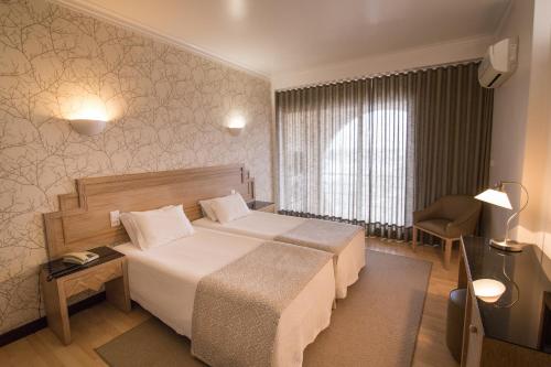 贝雅梅利斯酒店的配有一张床和一把椅子的酒店客房