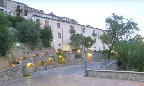 莫拉诺卡拉布罗Villa San Domenico的一座白色的大建筑,设有石墙和楼梯