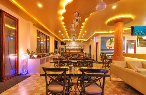 马富施日出海滩公寓式酒店的餐厅设有桌椅和沙发。