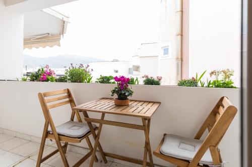 雅典Holargos Metro Rooms的阳台配有一张小桌子和两把椅子