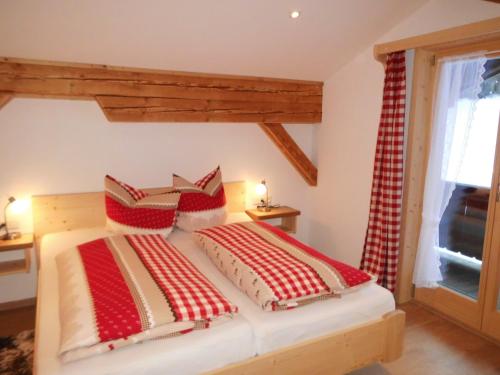 雷特温克尔Seewiesenalm的一间卧室配有红色和白色枕头的床