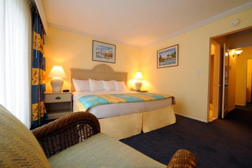 拿骚天堂岛湾景套房度假村的配有一张床和一把椅子的酒店客房