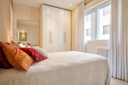 阿雷格里港HomeStay 3 - Avenida Carlos Gomes的卧室配有白色的床和窗户。
