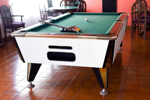 阿肖海马尔阿霍旅馆的一张带有线索和球的台球桌