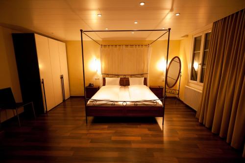 阿尔特多夫金钥匙酒店及餐厅的一间卧室,卧室内配有一张天蓬床