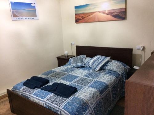 罗萨里奥港Bounty Bedroom的一间卧室配有一张带两个蓝色枕头的床