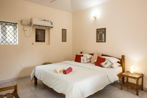 卡乌罗西姆Villa La Casita的一间卧室配有两张带白色和红色枕头的床