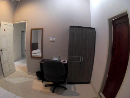 万慈威斯马哈拉尼旅馆的客房设有书桌、椅子和镜子
