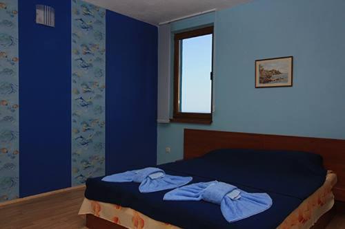 辛尼莫雷特Complex Koral的一间卧室配有一张蓝色墙壁的床和一扇窗户