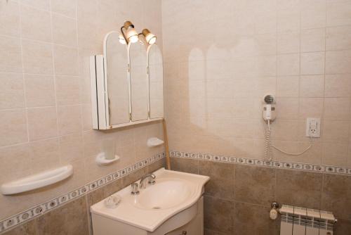 埃尔卡拉法特卡瓦尼斯德内公寓的一间带水槽和镜子的浴室以及一部电话