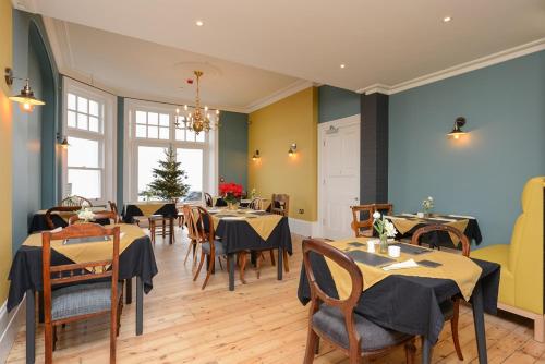 布罗德斯泰Bay Tree Broadstairs的一间在房间内配有桌椅的餐厅