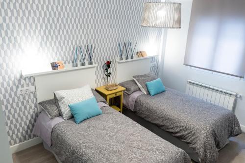 巴利亚多利德Apartamento Garval Valladolid的一间卧室配有两张带蓝色枕头的床