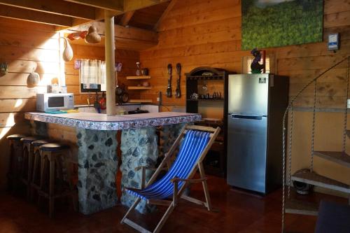 迦太基La Flor de Loto的厨房设有1间带冰箱和椅子的酒吧
