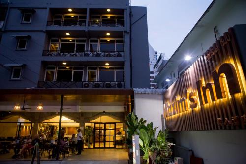 曼谷美心酒店的一座建筑,人们在晚上坐在外面