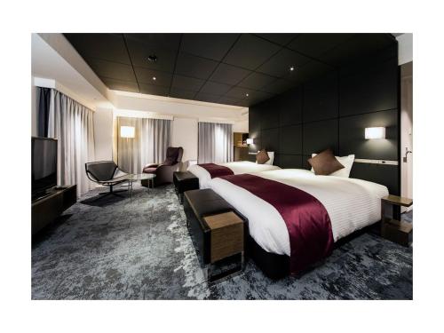 东京Daiwa Roynet Hotel Ginza PREMIER的酒店客房设有两张床和一台平面电视。