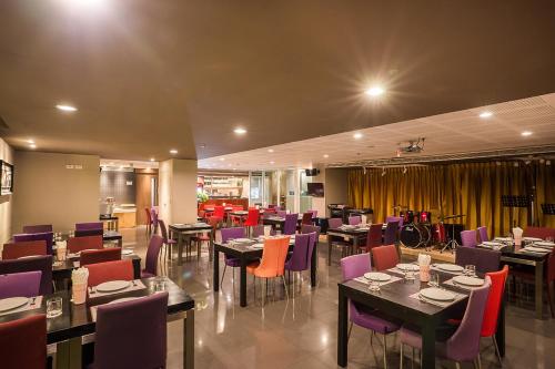 曼谷超越套房酒店的一间带桌子和紫色椅子的用餐室