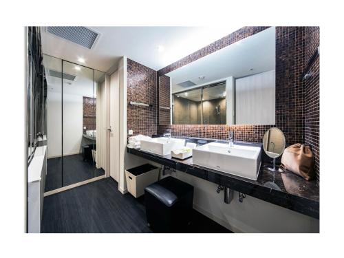 东京Daiwa Roynet Hotel Ginza PREMIER的一间带三个水槽和大镜子的浴室