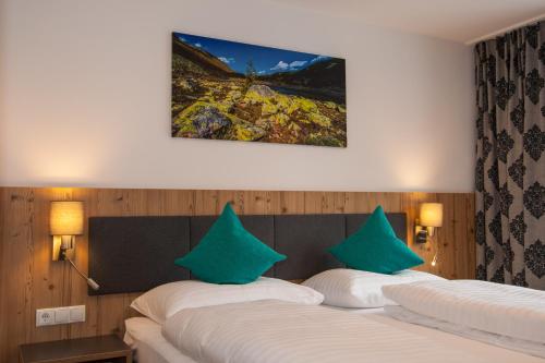 圣安东阿尔贝格Haus Sattelblick的配有绿色枕头的酒店客房内的两张床