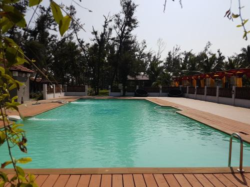 钦奈VGP黄金海岸度假酒店的一个带木制甲板的大型蓝色游泳池