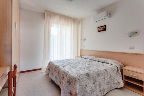 丽都阿德里亚诺Aparthotel Costa Paradiso的酒店客房设有床和窗户。