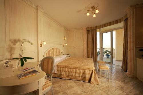 阿尔巴·阿德里亚蒂卡包拉凯酒店的一间卧室配有一张床、一张桌子和一个水槽