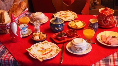 奥特罗特Chambres d'Hôtes Chez Mado Ottrott的一张桌子,上面有红色的桌布,上面有食物和饮料
