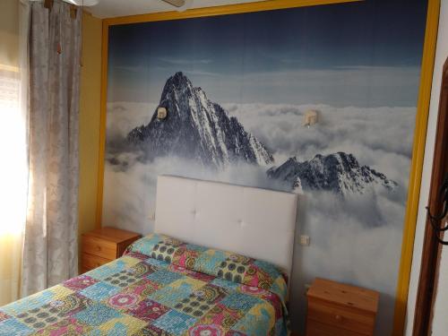 阿雷纳斯德圣佩德罗大道旅馆的卧室的墙上挂有山壁画