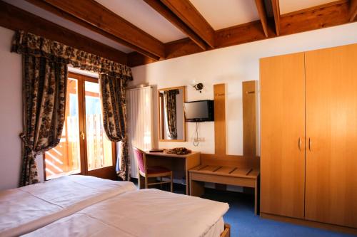 摩德纳迪-坎皮格里奥弗蒂尼酒店的一间卧室配有一张床、一张书桌和一个窗户。