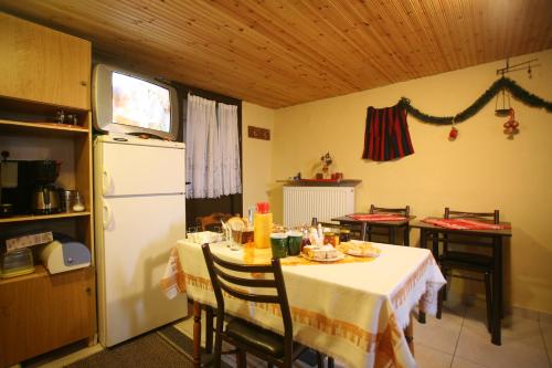帕雷斯阿吉萨那Eleni's Guesthouse的厨房配有桌子和白色冰箱。