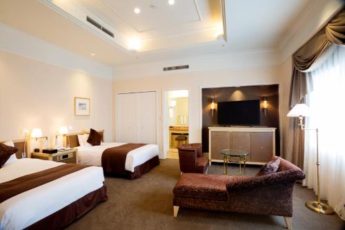 札幌东急札幌卓越大酒店的酒店客房设有两张床和一台平面电视。