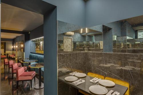 罗马奥迪维姆酒店的一间带桌椅的餐厅和一间酒吧