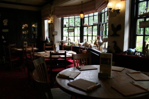 布莱斯The Angel Inn (Blyth)的用餐室设有桌椅和窗户。