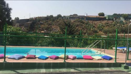因赫尼奥Aguatona的游泳池周围设有色彩缤纷的枕头