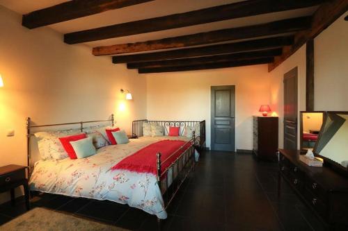 MontembœufLa Bucherie的一间卧室配有一张带红色枕头的大床