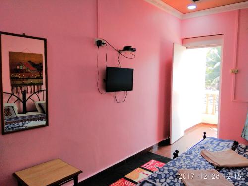 帕罗林Sobitai的粉红色的房间,设有床铺和墙上的电视