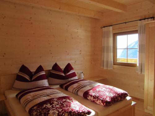 海利根布卢特Ebner Casa的小木屋内的两张床,设有窗户