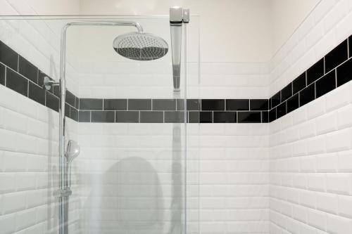 波尔多Le Clos Labottière - B&B的浴室铺有黑白瓷砖,设有淋浴。