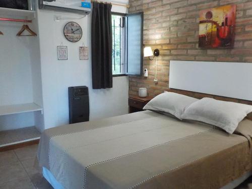 圣罗莎卡拉穆奇塔县Portal del Río Posada的一间卧室设有一张大床和砖墙