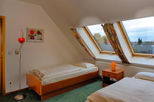 吕贝克理想酒店的一间小卧室,配有两张床和窗户
